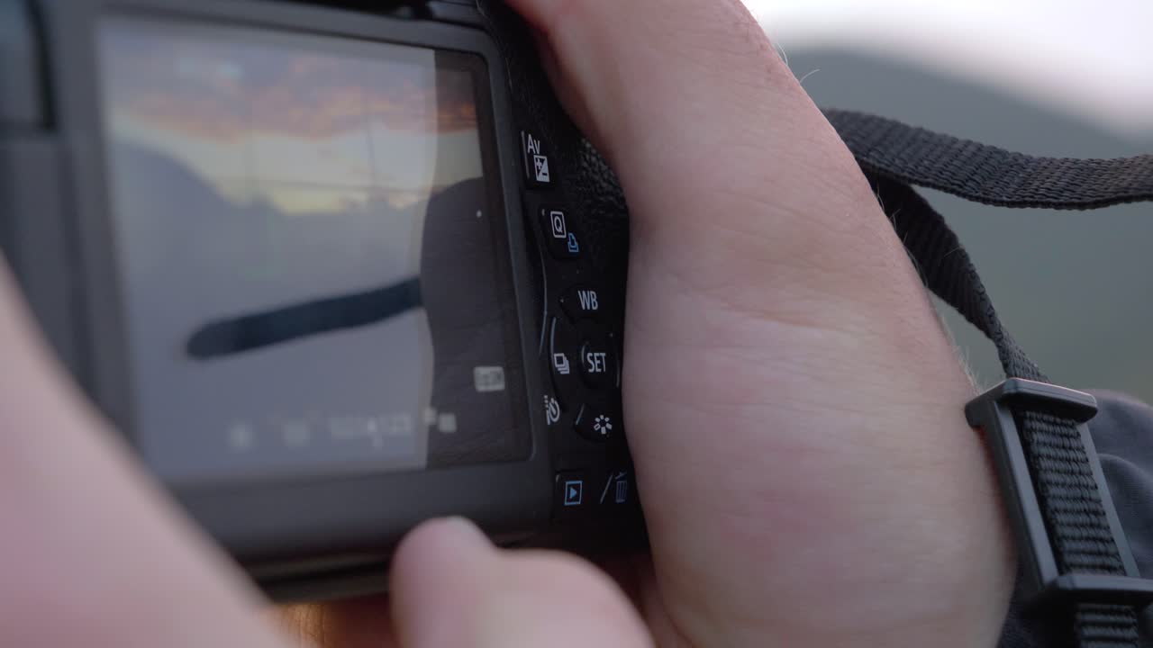 Close-up Of A Young Man Taking A Picture With A Canon Reflex Camera in slowmotion in exterior with cloudy blue sky