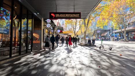 people walking along a sunny city street