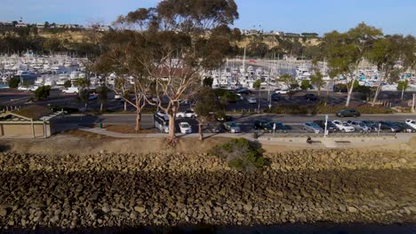 Aerial-dolly-along-erosion-control-rock-wall-with-full-harbor-behind