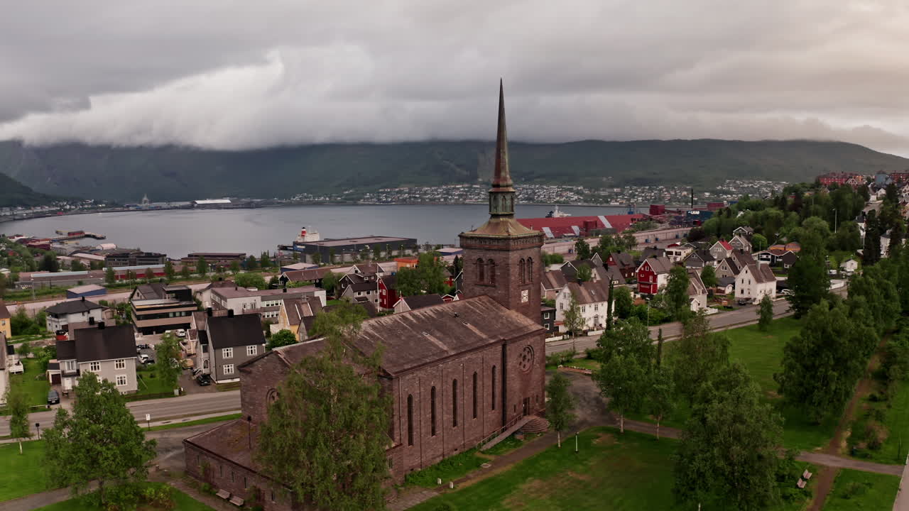 Aerial drone shot over the city of Narvik in Norway. High view of the local church, houses and buildings of the nordic town.