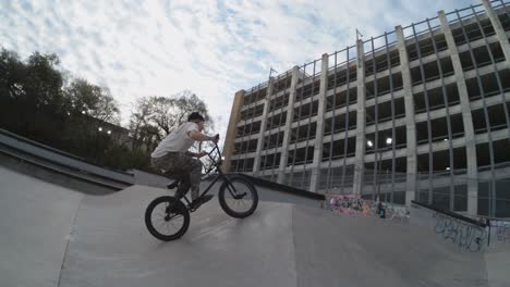 Biker-Dreht-Sich-In-Zeitlupe-Um-360-Grad-Im-Skatepark,-Beanie-Fliegt-Davon,-4K-800fps-BMX-Trick-Bei-Sonnenaufgang