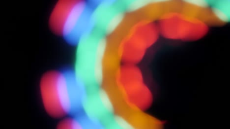 colorido baile arco iris círculo bokeh fondo. espectro de arco iris de colores. baile de discoteca y música electrónica moviéndose abstractos papel tapiz borroso. colorido haz de luz y rayo en fondo negro.