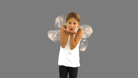 little girl wearing dragonfly wings on grey screen