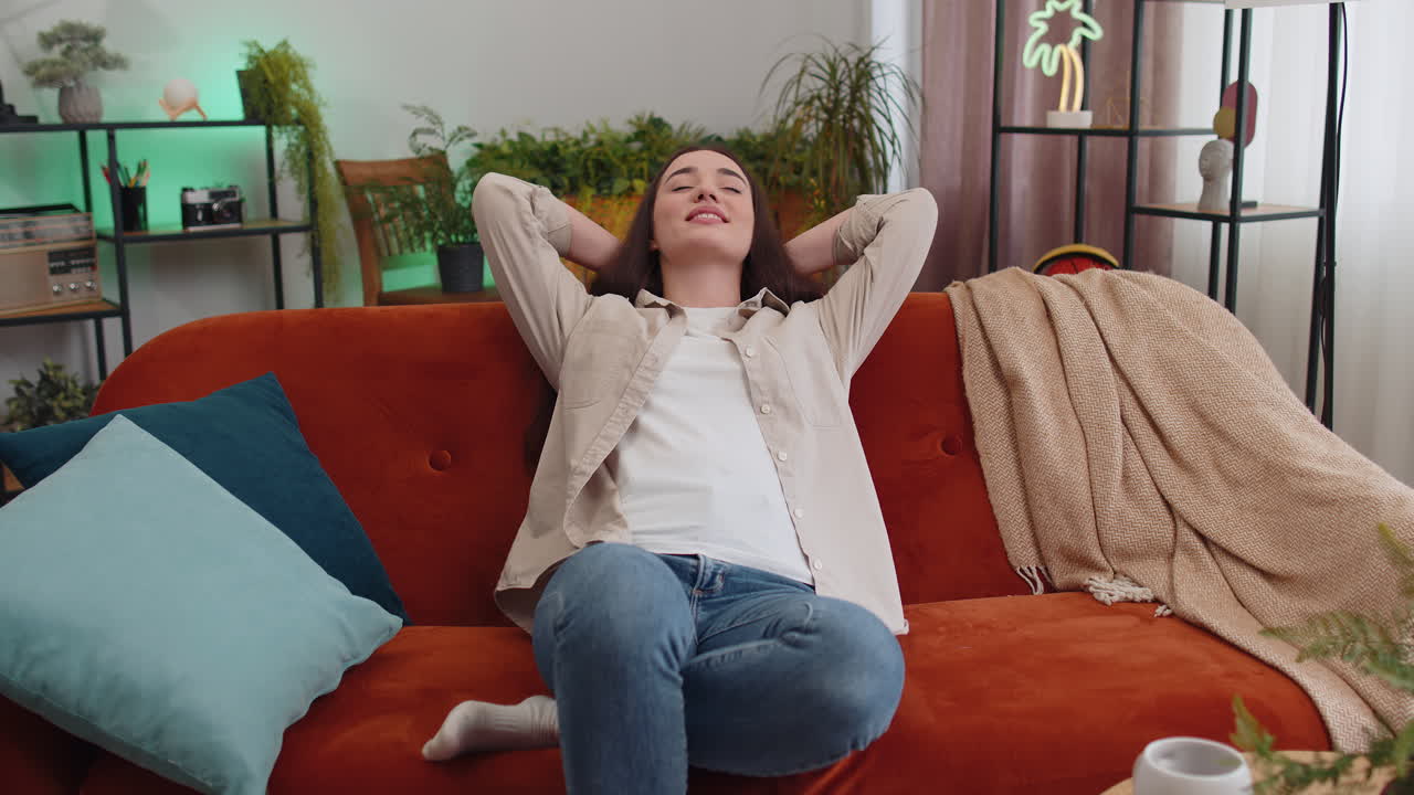 Tired lazy woman enjoy relaxing on home sofa resting napping after hard working day closed her eyes