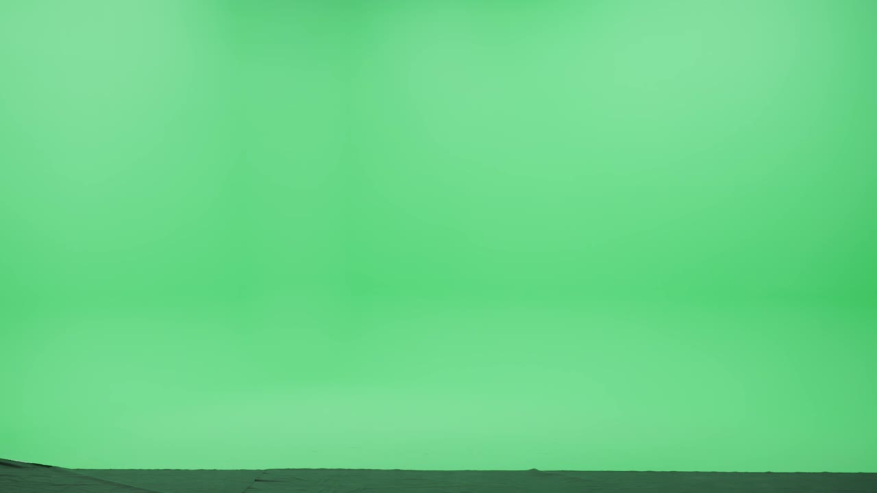 estúdio de tela verde: jovem mulher usando mochila e fones de ouvido usando smartphone para navegar pela internet e mídias sociais, escuta música ou podcast caminha felizmente pela sala de chave de croma