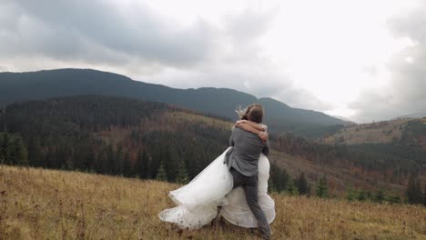 Lovely-newlyweds-bride-groom-dancing-on-mountain-autumn-slope-in-slow-motion,-wedding-couple-family