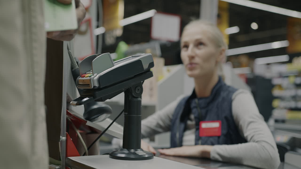 Customer paying with credit card at grocery store checkout