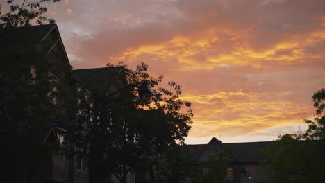 Establishing-shot-of-townhouses-roofs-during-golden-hour-as-a-bird-flies-through-the-frame