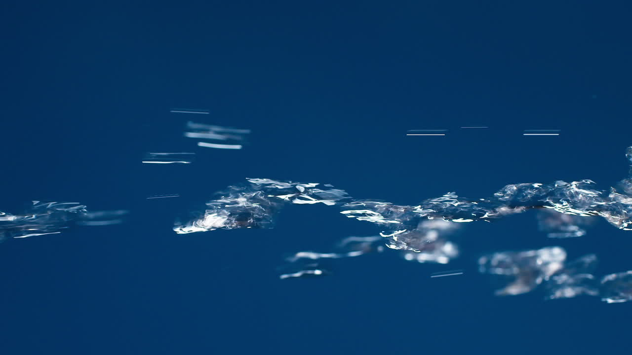 슬로우 모션으로 촬영하는 파란색 배경에 물이 튀면서 흐르는 진짜 순수한 물의 수직