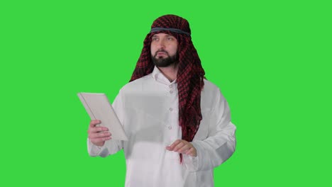 sheikh using digital tablet and walking on a green screen, chroma key