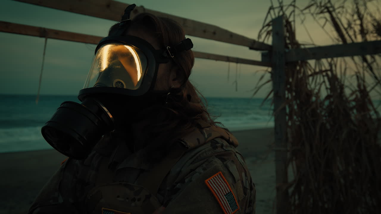 Radiation contaminated beach in wartime. Soldier with gas mask near stormy ocean