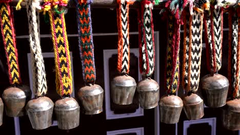 some yak bells hanging in a line waiting for someone to buy them