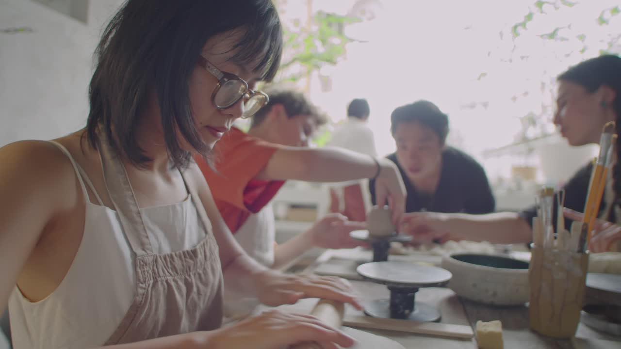 Asian Girl Rolling Clay on Pottery Masterclass