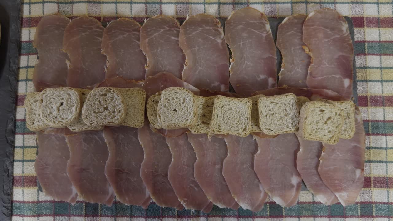 Top View Of Delicious Pork Charcuterie With Small Toasts On Colourful Cloth