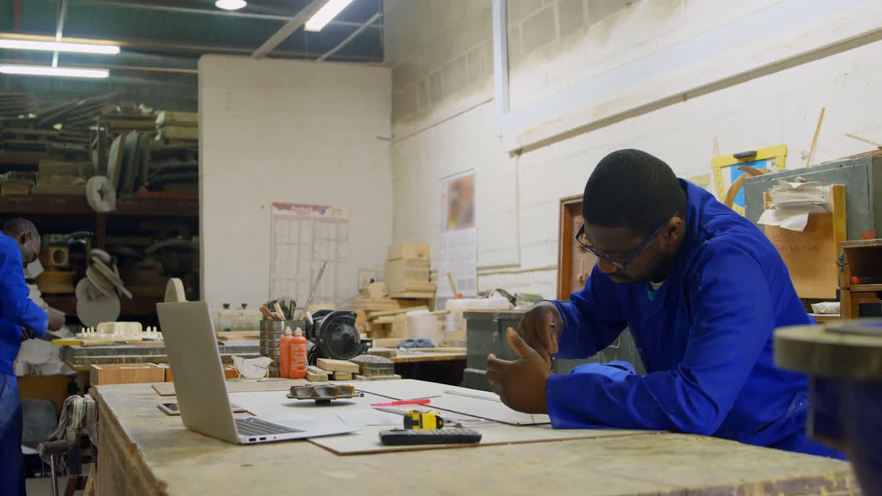 Worker working at table in workshop 4k