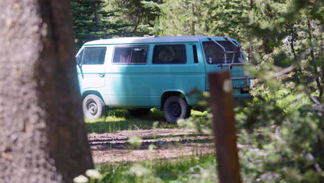 vintage van parked in sunlit forest clearing, pull focus