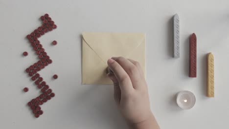 wax sealing letter using wooden classic seal, top view