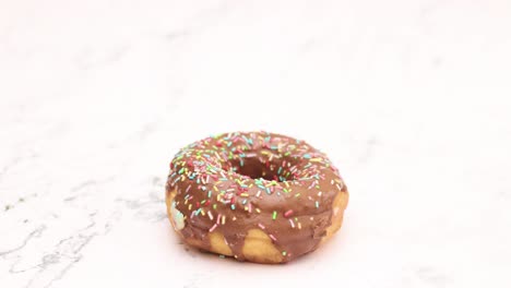 deliciosas rosquillas decoradas con chocolate negro y migajas giran en círculo - detenga el movimiento