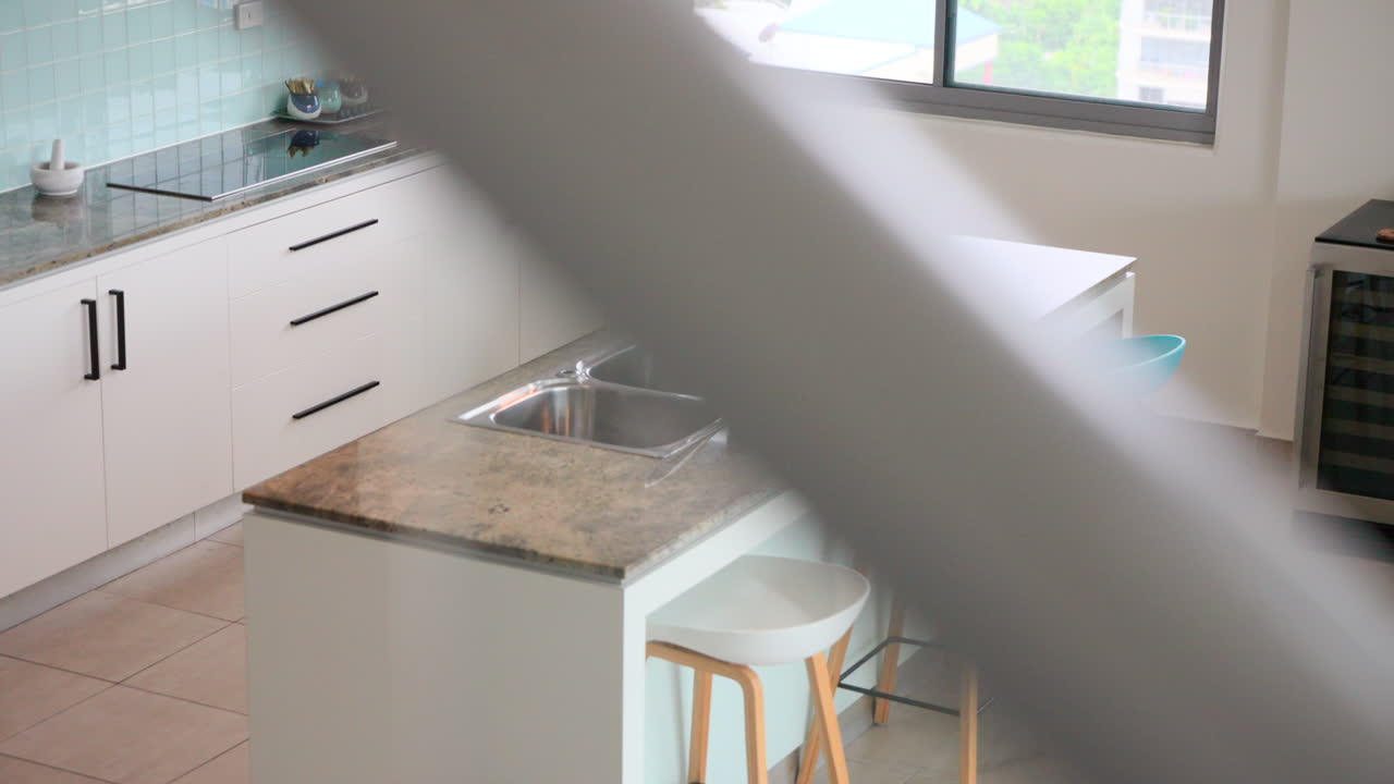 Dapur yang terungkap di balik tangga kaca, memaksimalkan ruang meja dapur dan lemari