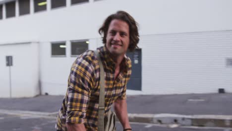 caucasian male smiling and riding his bike in a street