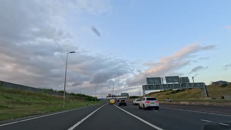 cars travel on highway towards iconic bridge