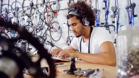 mecánico usando una computadora portátil en el taller