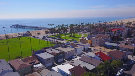 aerial view of a coastal town with a pier and palm trees