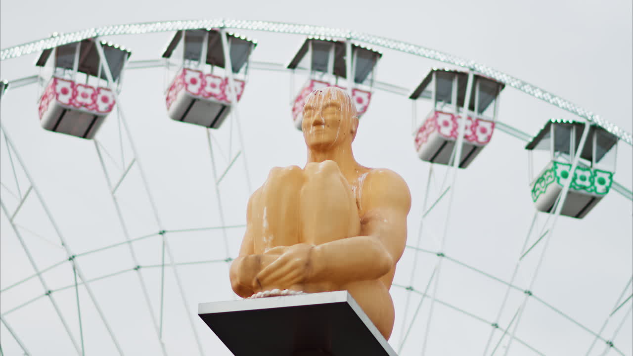Nice, France - December 8, 2024: Conversation a Nice statue by Jaume Plensa at Place Massena with a ferris wheel on the background