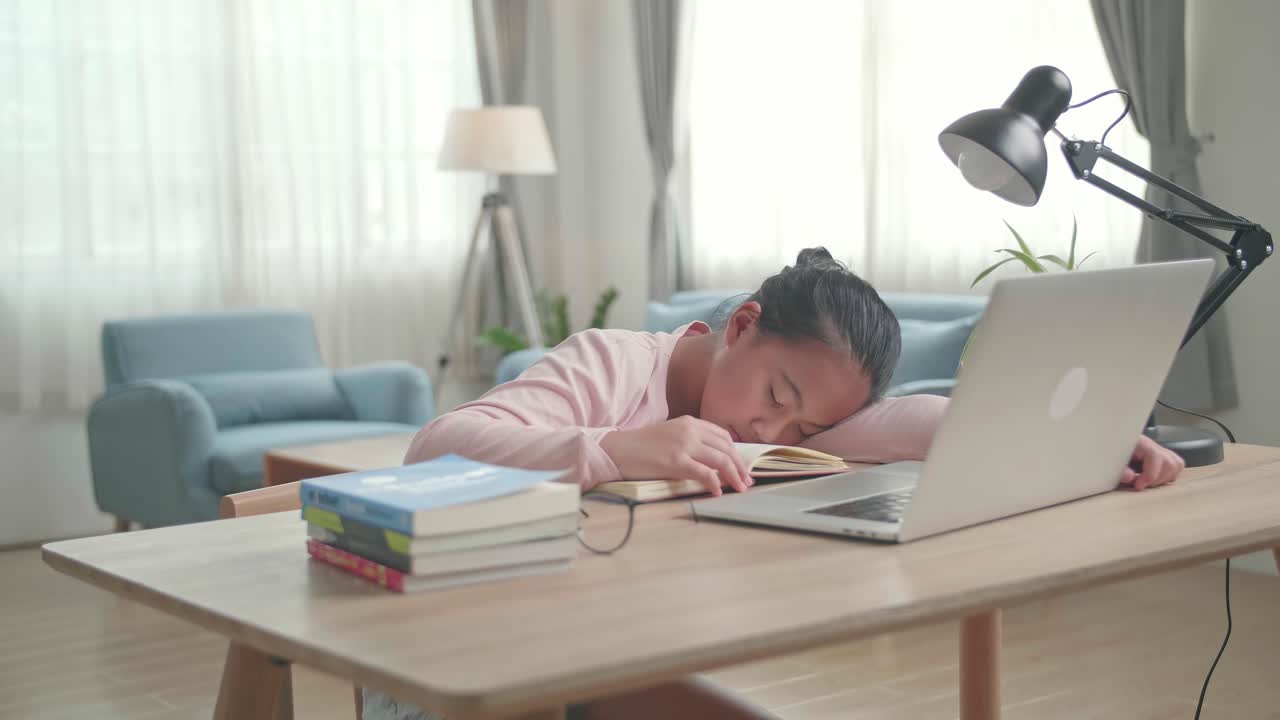 Tired Asia Girl Sleep On The Table At Living Room After Doing Home Work