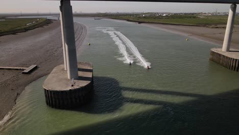 jet ski riders on race under sheppey crossing on at summer in kent, united kingdom