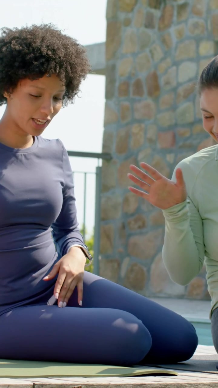Vertical video: Seeing friend with phone, navy-clad woman gesturing and laughing on rooftop mats