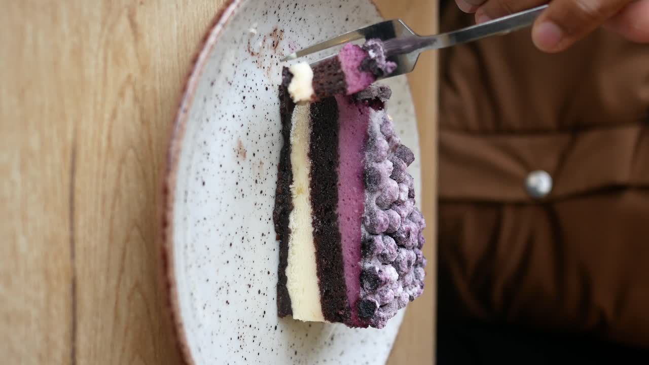 Person Eating a Slice of Berry Cake