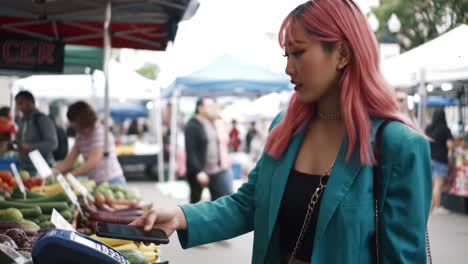exploring a vibrant farmer's market: a young woman engages with fresh produce and local vendors in an outdoor shopping experience