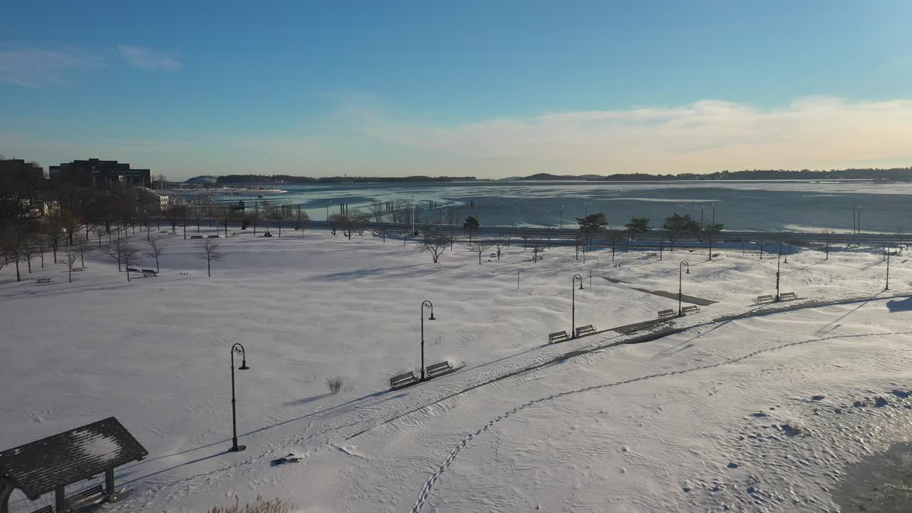햇빛과 푸른 하늘이 있는 바다 옆의 눈보라 후 공중 촬영