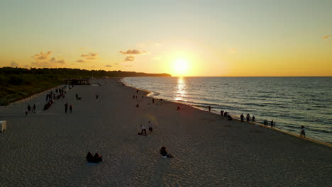 gente disfrutando de la puesta de sol en la costa del mar báltico en polonia, antena
