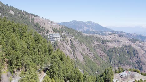 mountainous landscape with coniferous forest and buildings, hill station