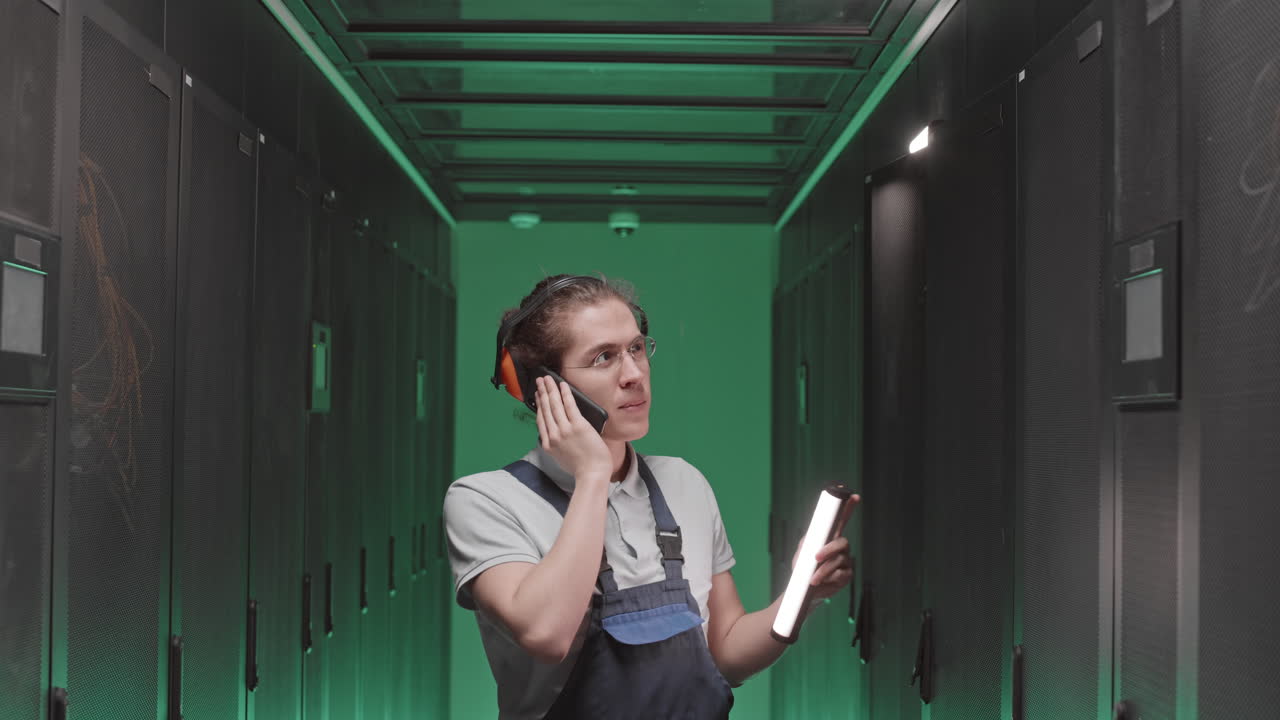 IT Technician Talking on Mobile Phone in Server Room