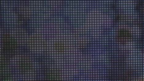 Extreme close-up shot: an LED grid display, featuring large illuminated dots that change color in an animated sequence