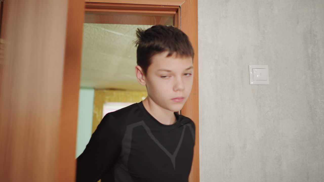 L'adolescente si ferma in silenzio. La persona giovane si arresta con gli occhi chiusi silenziosamente. L'individuo giovane si ferma all'ingresso con una quieta immobilità. Il giovane ragazzo sta in silenzio con gli occhi chiusi prima di entrare nella stanza.