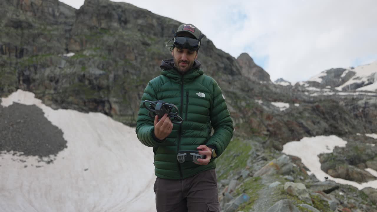 Drone pilot grabbing Dji Avata 2 drone wearing glasses and flying in mountains