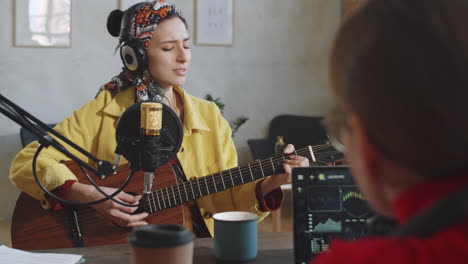 Música-Cantando-Y-Tocando-La-Guitarra-En-El-Estudio-De-Podcast