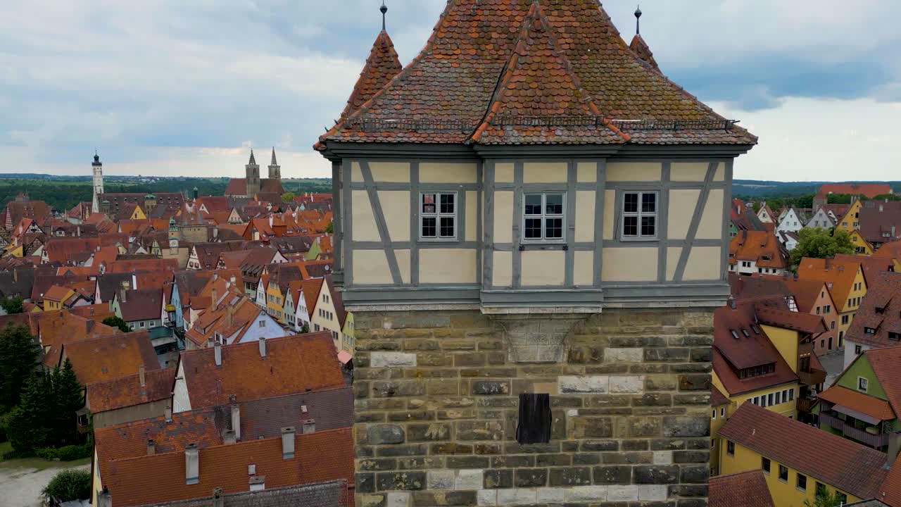 4K Aerial Drone Video of the Röderturm Tower on the Walled City of Rothenburg, Germany with the Historic Town Hall and Iconic Gothic St. Jakobskirche Church in the Distance