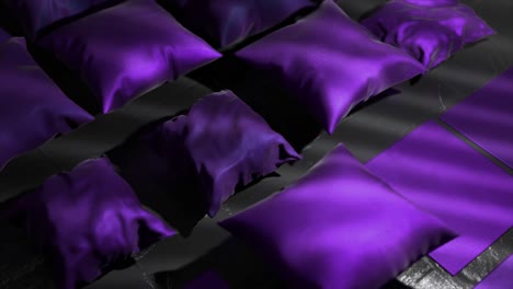 purple satin pillows on dark background