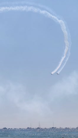 planes drawing patterns in the sky above beachgoers