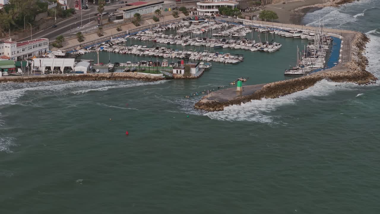 Aerial pedestal shot showing a marina filled with boats and yachts on the coast of Málaga