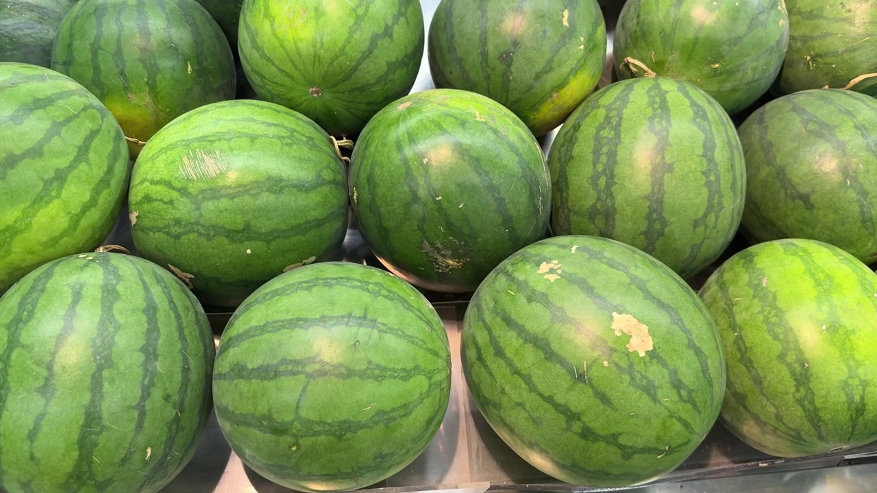 Angurie verdi fresche esposte in un mercato