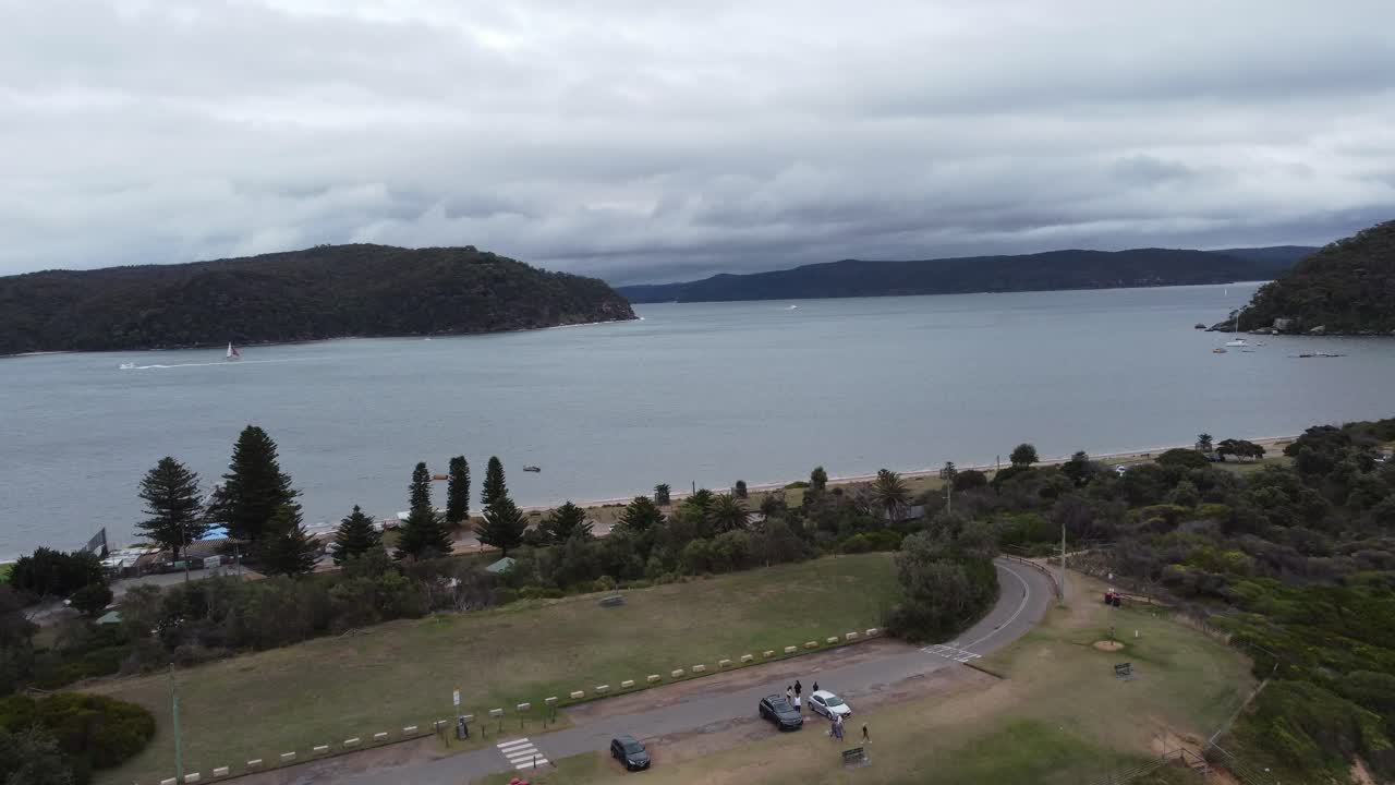 반도의 반대편에 있는 만을 드러내는 주차장 위를 날아다니는 드론