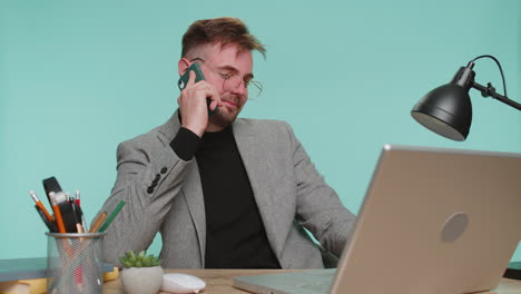 Feliz-Jefe-De-Hombre-De-Negocios-Disfrutando-De-Una-Llamada-De-Teléfono-Móvil,-Hablando-Con-Un-Colega-En-El-Escritorio-De-La-Oficina