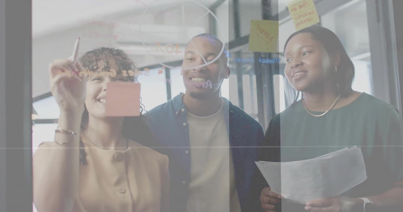 Left team member reaching with marker and placing sticky note, business team brainstorming on glass