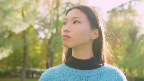 portrait of a young asian woman in a park